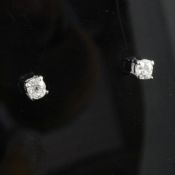 A pair of 18ct gold and solitaire diamond ear studs, the two old round cut stones with a total