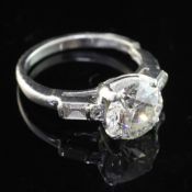 A 20th century platinum and single stone diamond ring, with baguette and diamond chip set shoulders,