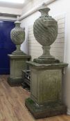 A large pair of reconstituted stone popes urns, with half gadrooned riven bodies, each on a large