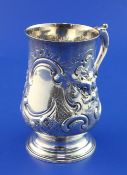 A George III silver baluster mug, with acanthus leaf capped handle and later embossed foliate scroll