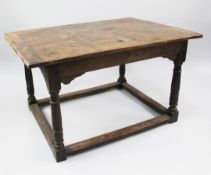 A 17th century oak altar table, the planked top with cleated ends, on turned gun barrel supports