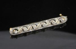 An Edwardian Belle Epoque gold, platinum and diamond set pierced scrollwork bar brooch, 2in.