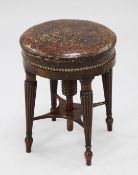 A Regency rosewood circular revolving piano stool, with brown leather and brass studded seat, on