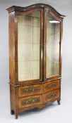 A 19th century French serpentine walnut and ormolu mounted display cabinet, the arched top with