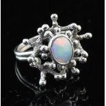 A 1970's 9ct white gold and white opal set free form ring by John Donald, with central oval stone,
