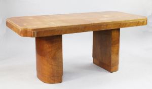 An Art Deco satin walnut dining table, the top with shaped ends on twin bow end column pedestal