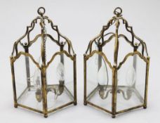A pair of gilt metal pentagon shaped hall lanterns, with arched glazed panels, each with triple