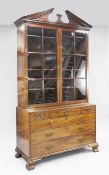 A George III mahogany bookcase, with broken arched pediment and two astragal glazed doors above an