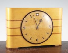 A Metamec electric mantel timepiece, with mahogany inlaid blond wood case and burr wood dial, and