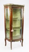 A French Transitional style marble topped mahogany vitrine, with gilt metal mounts, shaped glass