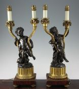 A pair of 19th century French bronze and ormolu twin branch candelabra, each modelled as cherubs