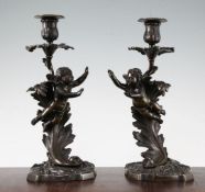 A pair of late 19th century patinated bronze candlesticks, each modelled with an acanthus leaf and