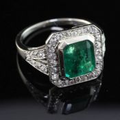 A white gold, emerald and diamond set octagonal ring, the central emerald weighing 1.94ct, with