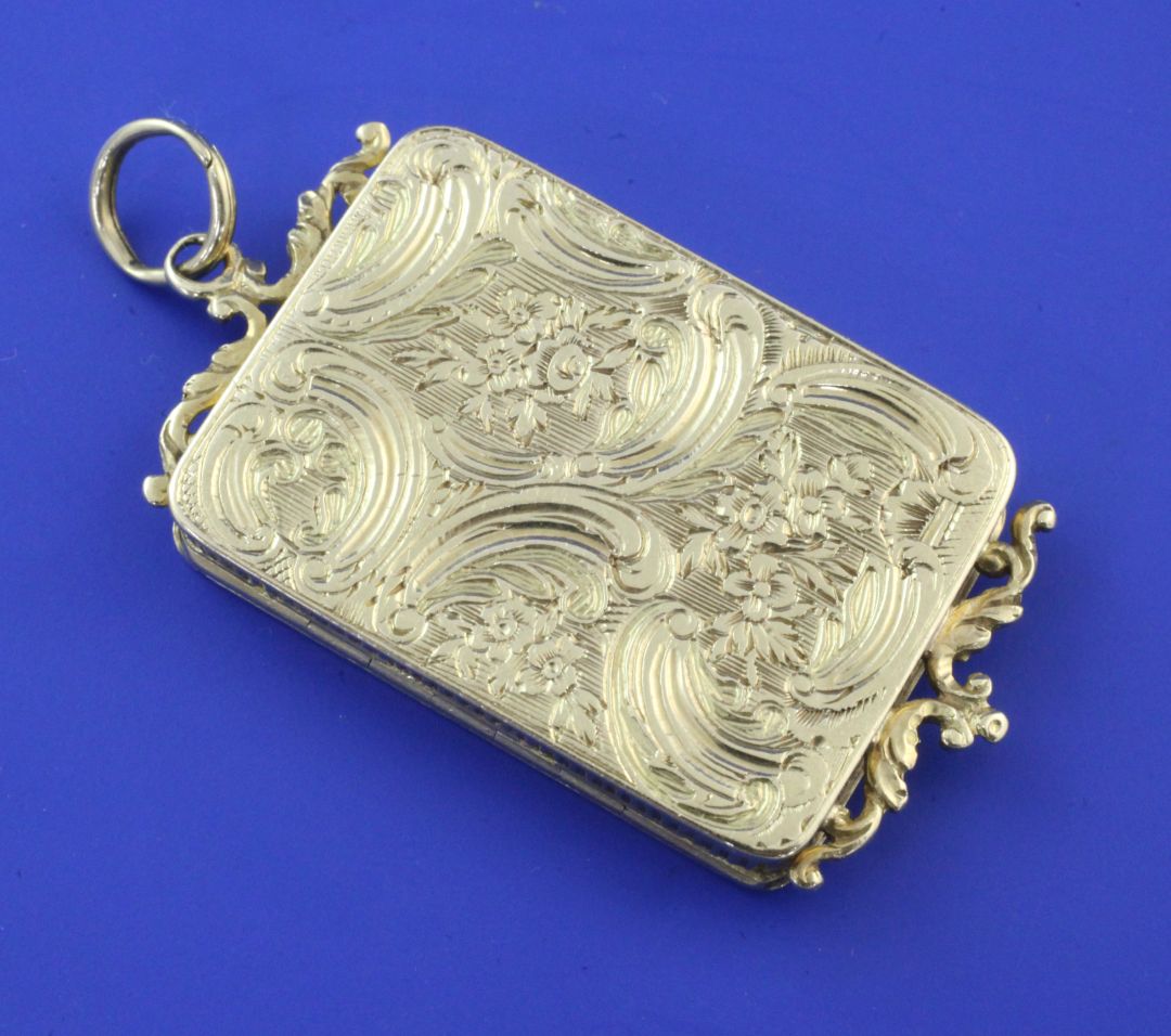 A continental high carat gold rectangular vinaigrette, with two scroll surmounts and engraved with