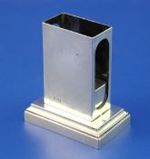 An Edwardian silver matchbox holder by R & S Garrard & Co, on rectangular plinth base, London, 1902,