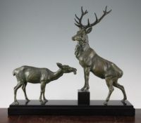 An Art Deco patinated metal study of a stag and doe, on a stepped rectangular base, signed L.
