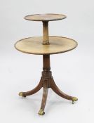 A George III mahogany two tier circular dumb waiter, with tapering turned supports and reeded