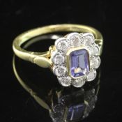 A modern 18ct gold, tanzanite and diamond cluster ring, of oval form, set with emerald cut tanzanite