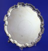 An early 1930's silver salver, of circular form with pie crust border, on three scroll feet, Adie