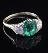 A Victorian style 18ct gold, three stone emerald and diamond ring, the central emerald weighing
