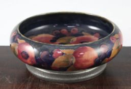 A William Moorcroft pomegranate pattern Tudric pewter mounted bowl, c.1920, the shallow bowl with