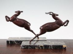 A pair of Art Deco patinated metal bookends, modelled as leaping gazelles, on rectangular marble