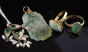 Three items of gold and jade jewellery including two rings and a carved pendant, together with an