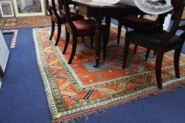 A Turkish carpet, with three central hooked diamond motifs in a field of geometric shapes, on a