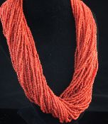 A mid 20th century Indian multi strand coral bead necklace, with coin clasp, gross weight 156 grams,