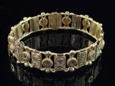 An early 20th century Indian 22ct gold hinged bangle, of openwork design, with engraved