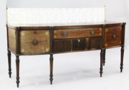 A George III mahogany sideboard, with brass curtain rail, bottom arrangement of cupboards and