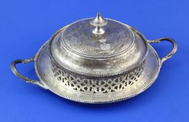 A Victorian pierced silver circular two-handled butter dish and cover, with glass liner and beaded