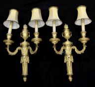 A pair of Louis XVI style ormolu twin branch wall lights, with central flaming urn, 22in. incl.