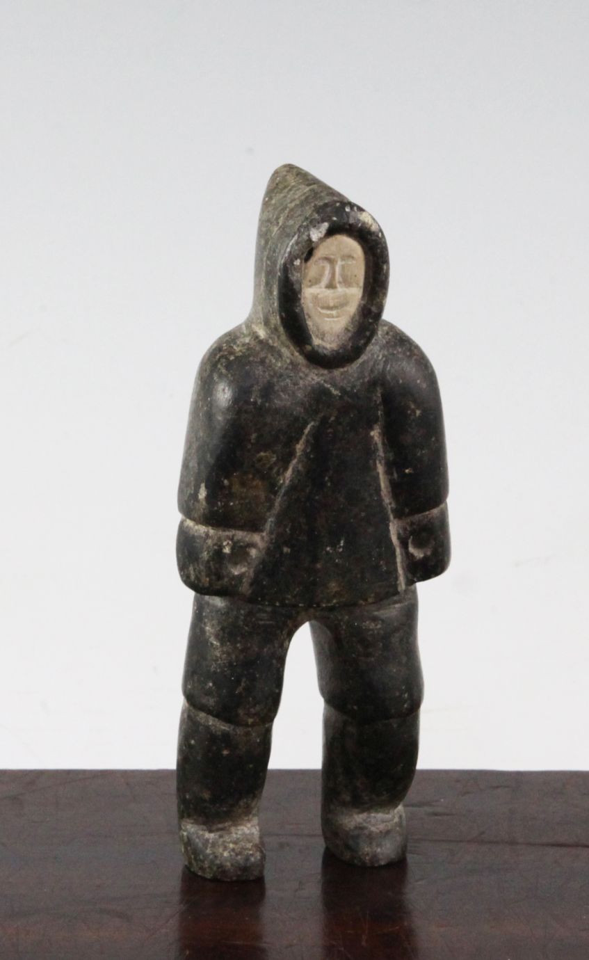 An Inuit carved soapstone figure of a male standing, wearing a thick coat and hood, 5.25in.