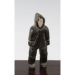 An Inuit carved soapstone figure of a male standing, wearing a thick coat and hood, 5.25in.