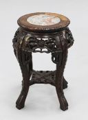 A small Chinese carved rosewood urn stand, with circular marble inset top, the scrolling legs united