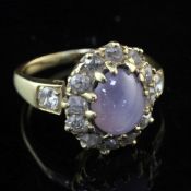 A gold, star sapphire and diamond oval cluster ring, set with old mine cut diamonds and diamond