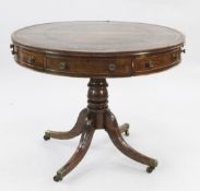 A George III mahogany drum top library table, with tooled green leather skiver, four frieze and four