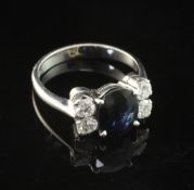 An 18ct white gold, sapphire and diamond ring, with central oval cut sapphire flanked by four