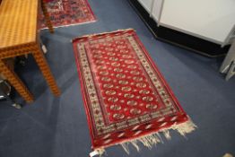 A Bokhara rug, with field of thirty six polygons on a red ground, with multi row border (worn),