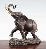 A 20th century patinated bronze elephant, with gilt brass tusks, monogramed FM, 9.5in.