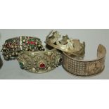 A collection of various Far and Middle Eastern jewellery, including Tibetan bangles, Balkan beadwork