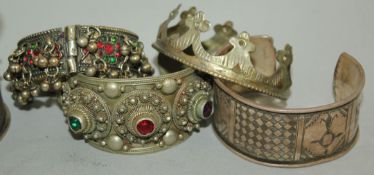 A collection of various Far and Middle Eastern jewellery, including Tibetan bangles, Balkan beadwork