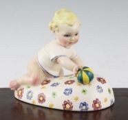 A Lenci pottery figure of a baby playing with a ball, 1930's, on an oblong base painted with