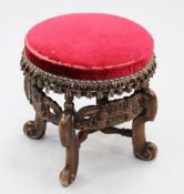 A Carolean style circular oak and fruitwood upholstered stool, the scrolled supports united by