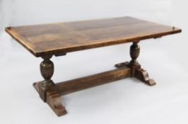 A 17th century style oak refectory table, the plank top with cleated ends, on cup and cover turned