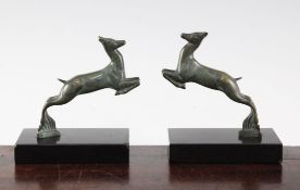 A pair of French Art Deco patinated bronze deer bookends, each on rectangular bases, marked