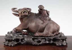 A Chinese carved hardwood group of a boy on an ox back, mid 20th century, the hardwood stand