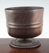 A late 17th century lignum vitae wassail cup, ring turned on circular spreading foot, 8in.