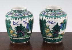 A pair of Japanese green Kutani ovoid jars, late 19th century, each decorated with pavilions in a